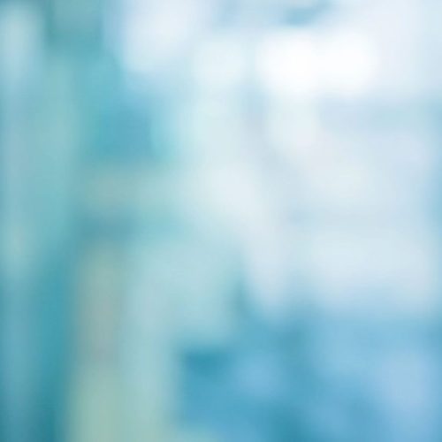 abstract blur soft focus blue color interior of modern cleaning workplace background with orange shine light for design concept